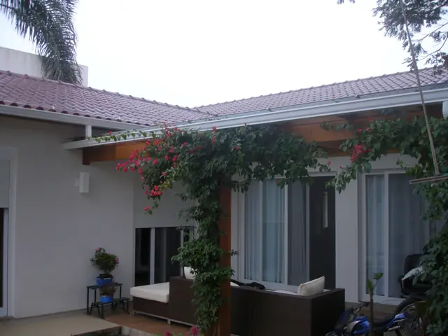 Casa térrea com varanda florida e calha no beiral